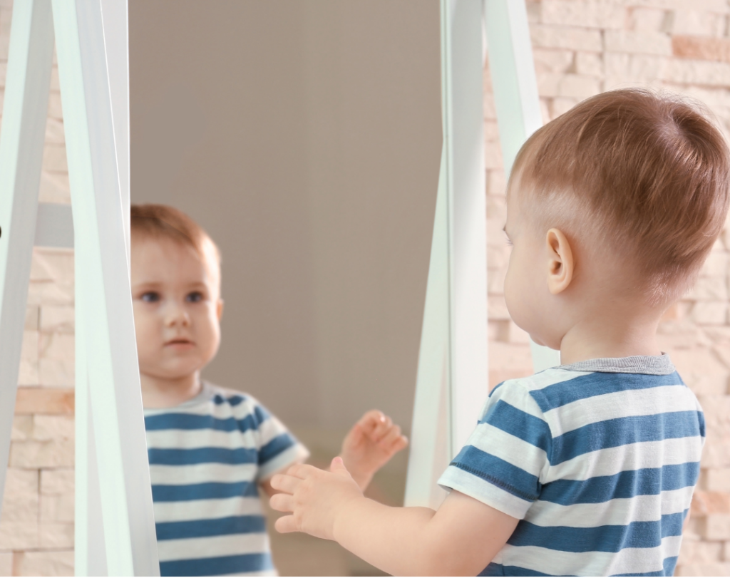 Baby kijkt in de spiegel en ziet zichzelf